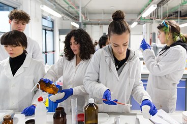 studenti in camice che lavorano con provette in laboratorio